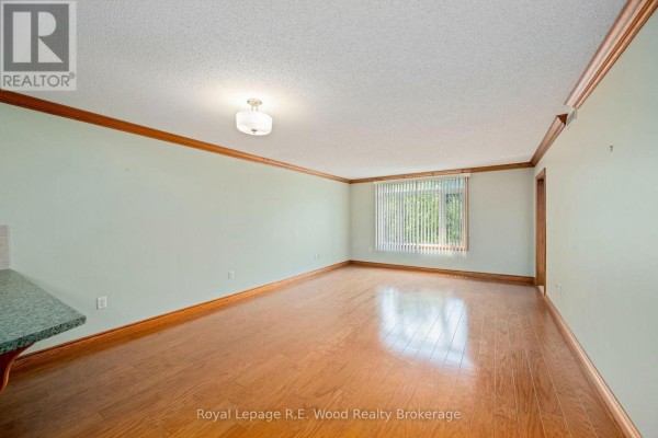 Communal lounge area with leather sofas, coffee table, and electric fireplace. - 205 - 80 Bridge Street E, Tillsonburg