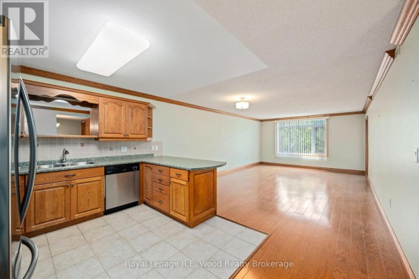 Library area with extensive wooden bookshelves filled with books. - 205 - 80 Bridge Street E, Tillsonburg