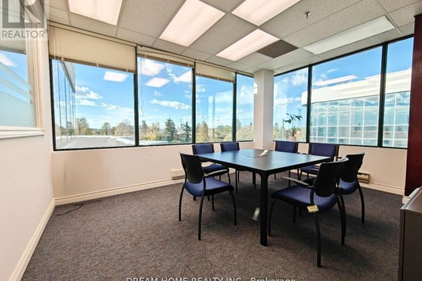 Office meeting room with a dark square table, blue chairs, and large windows with blinds. - 205 - A - 7800 Woodbine Avenue, Markham