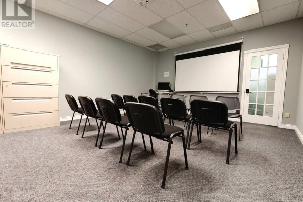Building lobby with a glass entrance, marble columns, and a wide staircase with glass railings. - 205 - A - 7800 Woodbine Avenue, Markham
