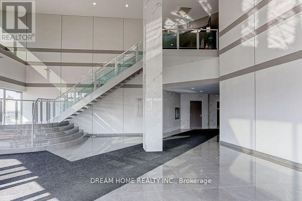 Interior of an elevator with light-colored walls, stainless steel accents, and horizontal grab bars. - 205 - A - 7800 Woodbine Avenue, Markham