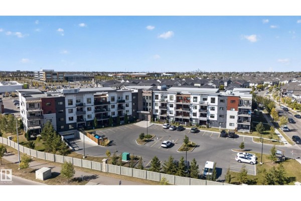 Wide aerial view of an apartment complex with surrounding suburban neighborhood and roads. - #205 1506 Tamarack Bv Nw, Edmonton