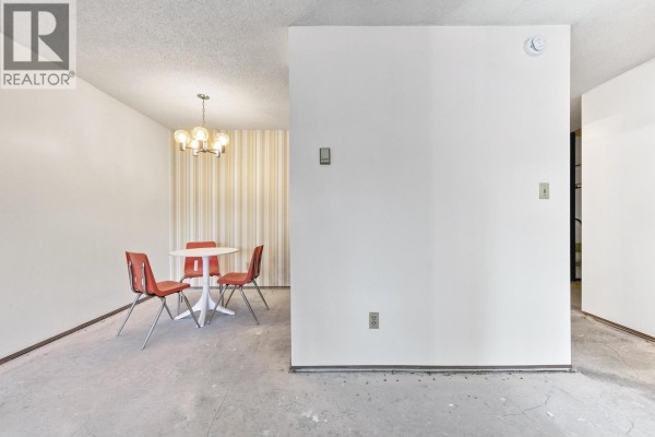 Dining area with red chairs and a round white table. - 205 1825 W 8th Avenue, Vancouver