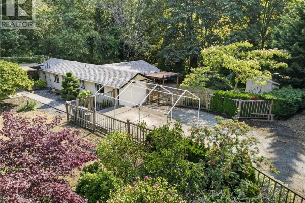 Overhead drone view of a house on a large, wooded lot. - 205 Atkins Rd, View Royal