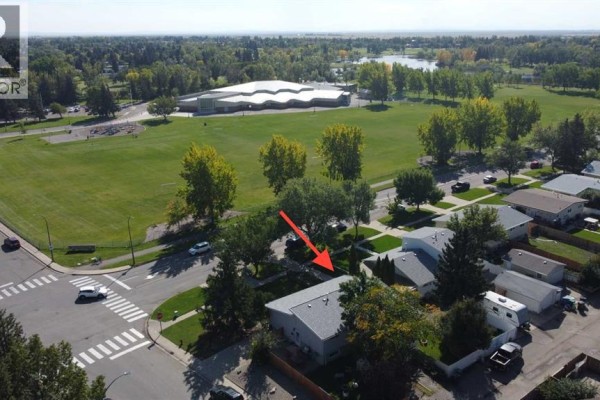 Aerial view of houses on Columbia Boulevard W, Lethbridge, adjacent to a park and school. - 205 Columbia Boulevard W, Lethbridge