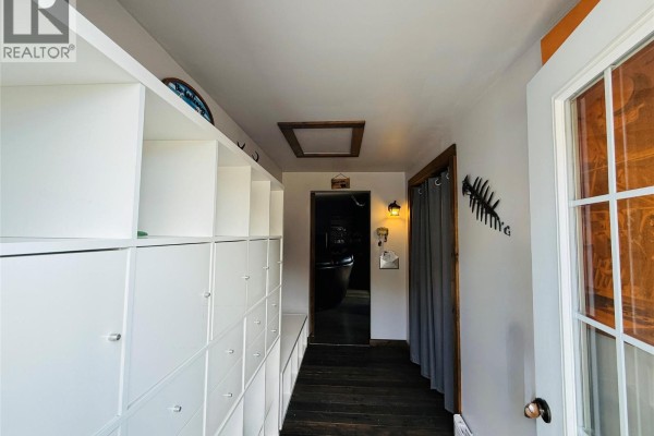 Living room with a spiral staircase, wood-burning stove, and dark leather seating - 205 Otis Street, Kimberley