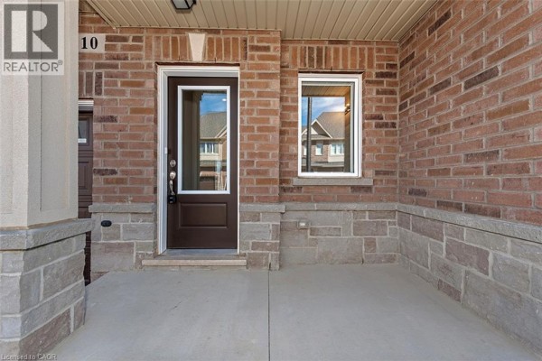Close-up of townhouse unit 10's entrance with a dark brown door and covered porch. - 205 Thames Way Unit# 12, Mount Hope