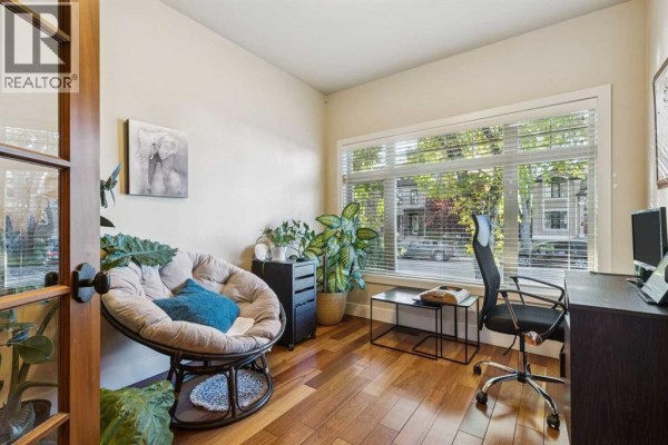Home office with a papasan chair, desk, computer, and large window. - 2050 47 Avenue Sw, Calgary