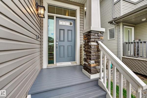 Wooden backyard deck with a barbecue, outdoor seating, and a bench. - 20503 99 Av Nw, Edmonton