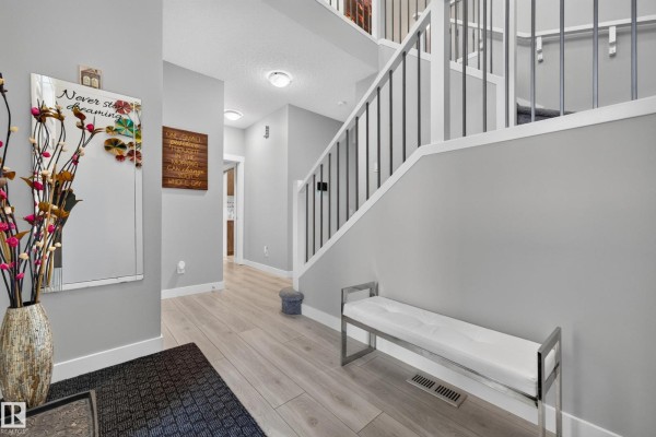 Bedroom with a bed, fan, and mirrored closet doors. - 20503 99 Av Nw, Edmonton