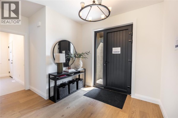 Open concept kitchen and living area with island, dining table, and backyard view. - 2056 Marion Avenue, Sarnia