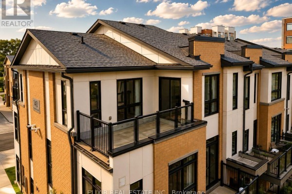 Aerial view of townhouse rooftops and balconies with glass railings. - 206 - 140 Canon Jackson Drive, Toronto