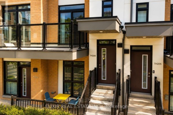 Close-up view of townhouse entrances TH206 and TH205, with small patio furniture. - 206 - 140 Canon Jackson Drive, Toronto