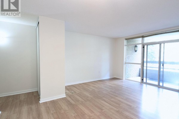 Living and dining area with light wood floors, armchairs, console table, and round dining table. - 206 - 284 Bloor Street W, Toronto
