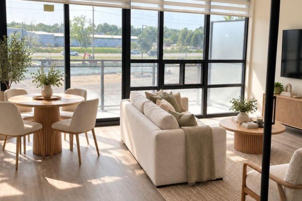 Aerial view of a long, modern apartment building on the edge of a calm lake. - 206 - 350 Prince Charles Drive S, Welland