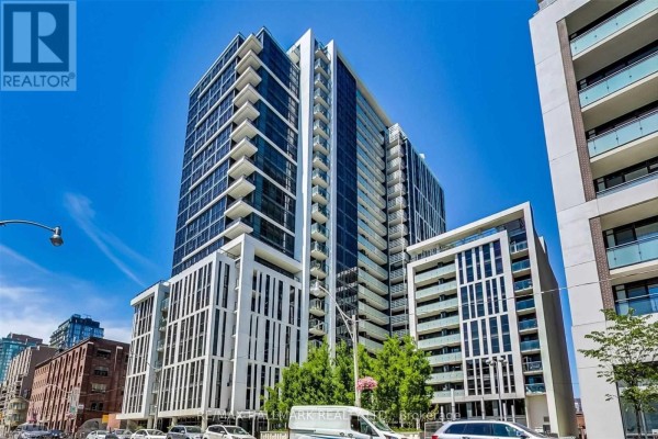 Tall modern condo building with white vertical fins and glass balconies against blue sky. - 206 - 400 Adelaide Street E, Toronto
