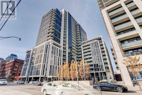Wide shot of tall condo building with glass balconies on a city street. - 206 - 400 Adelaide Street E, Toronto