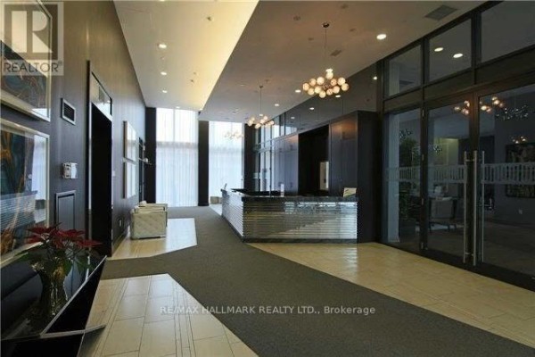 Lobby with dark wood panels, checkered floor, silver reception desk, and modern light fixtures. - 206 - 400 Adelaide Street E, Toronto