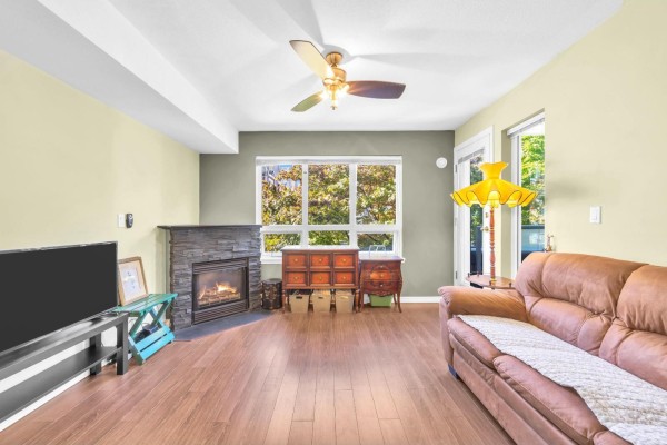 Ground-level view of the building with patio and landscaped garden. - 206 14355 103 Avenue, Surrey