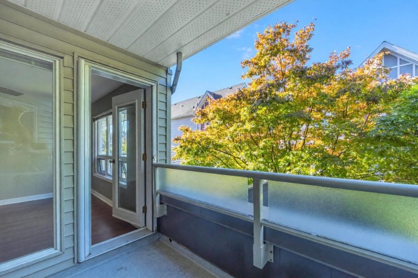 Entrance of the building featuring a covered awning and tiled walkway. - 206 14355 103 Avenue, Surrey