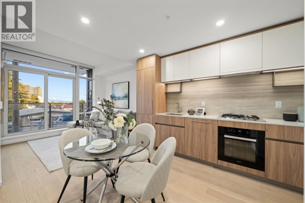 Open concept living and kitchen area with glass dining table, chairs, and modern cabinetry. - 206 8486 Oak Street, Vancouver