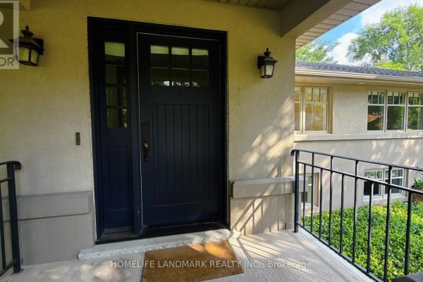Close-up of the dark blue front door with glass panels and black lanterns. - 2062 Glenforest Crescent, Oakville