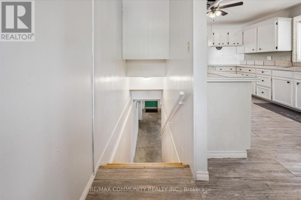 Staircase to green door, kitchen with white cabinets - 2063 George Street Howick