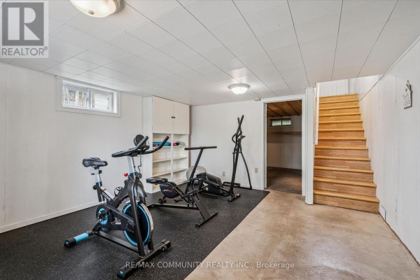 Home gym in finished basement with exercise bikes and stairs - 2063 George Street Howick
