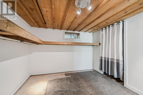 Finished basement with wood plank ceiling, exposed beams, and curtains - 2063 George Street Howick