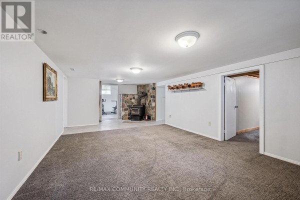Finished basement with stone fireplace and wood stove - 2063 George Street Howick