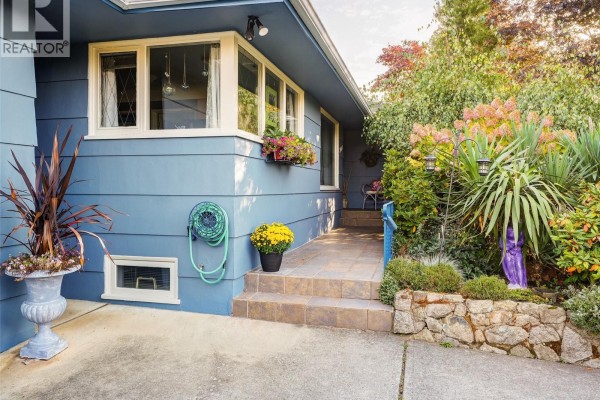Close-up of blue siding, walkway, and landscaping with stone accents. - 2064 Lansdowne Rd, Oak Bay