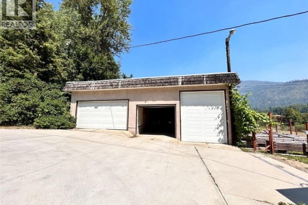Exterior of a detached three-car garage with white garage doors and concrete driveway. - 2066 Caughlin Road, Fruitvale