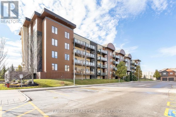 Side view of the building showcasing balconies and stone accents. - 207 - 100 Dean Avenue, Barrie