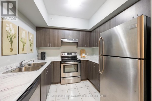 Modern kitchen with dark cabinetry, stainless steel appliances, and marble countertops. - 207 - 100 Dean Avenue, Barrie