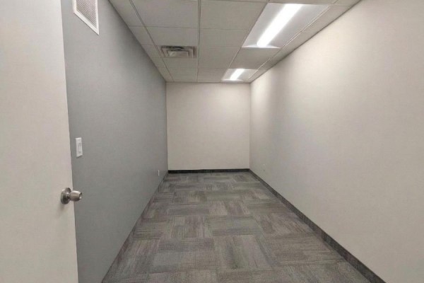 Office entryway showing a round meeting table and chairs, leading to desk area. - #207 - 5 Corvus Court, Ottawa