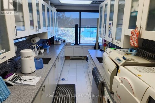 Functional kitchen space with white cabinetry and modern appliances - 207 - 712 Davis Drive, Newmarket