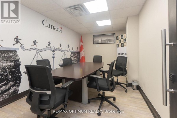 Hallway with glass doors and carpeted flooring, lined with offices. - 207 - 7895 Tranmere Drive, Mississauga