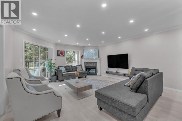 Living room with grey sofa, two accent chairs, coffee table, and sliding glass door to deck. - 207 1500 Ostler Court, North Vancouver
