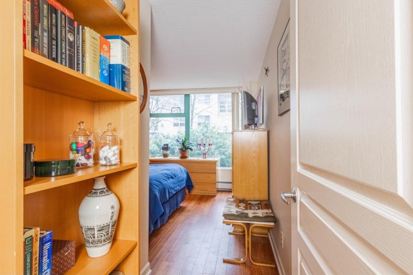Hallway view into bedroom with large window and television on dresser. - 207 15466 North Bluff Road, White Rock
