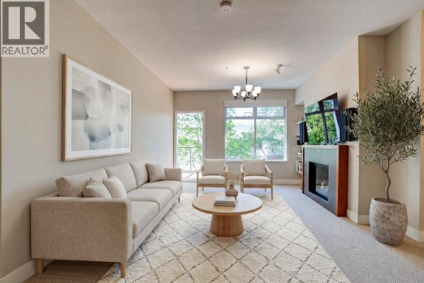 Open-concept living space with kitchen island, dining area, and living room. - 207 5955 Iona Drive, Vancouver