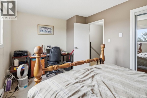Pathway leading through green space with trees and signage. - 207 991 Cloverdale Ave, Saanich