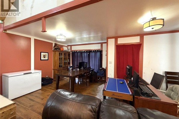 Interior view of a living room with a dining area, desk with computers, and a game table. - 207 Main Street, Hudson Bay