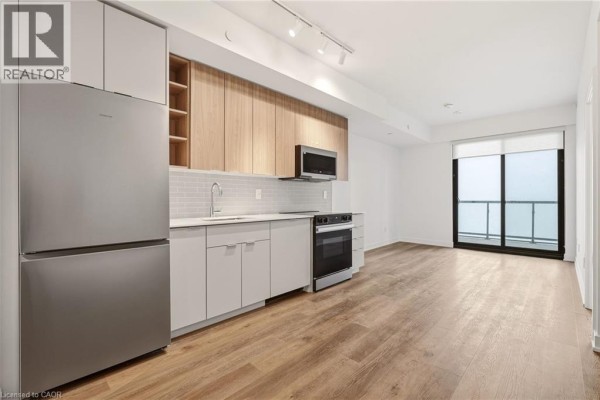 Empty room with white walls, wood-look flooring, and a mirrored sliding closet door. - 2075 Lakeshore Road Unit# 1106, Burlington
