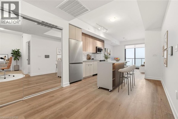 Open concept living space showing a kitchen area with stainless steel appliances and a dining area. - 2075 Lakeshore Road Unit# 1106, Burlington
