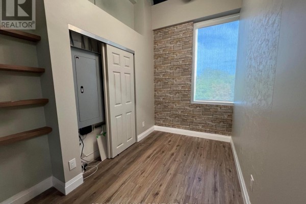 Modern office meeting room with white table, chairs, and decorative wall art. - 208 - 3485 Rebecca Street, Oakville
