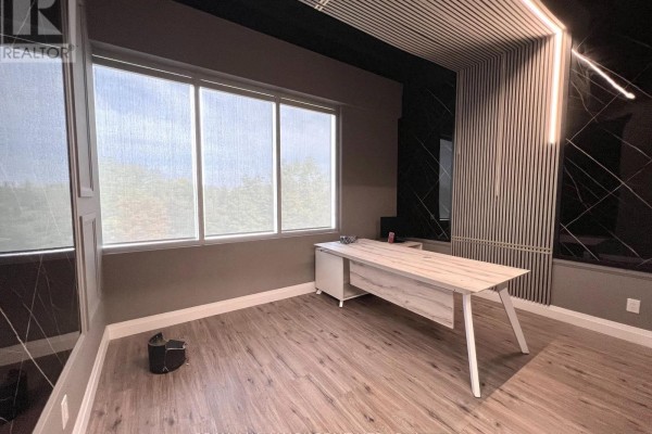 Office with desk, blue chairs, and large window overlooking a treed landscape. - 208 - 3485 Rebecca Street, Oakville