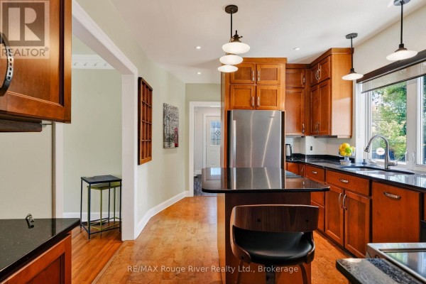 Kitchen with wood cabinets, granite island, and stainless steel fridge - 208 Albert Street Cobourg