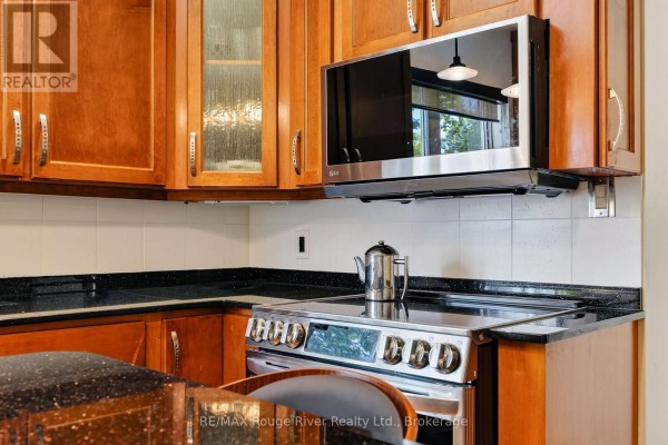 Stainless steel microwave and oven, wood cabinets, granite counters - 208 Albert Street Cobourg