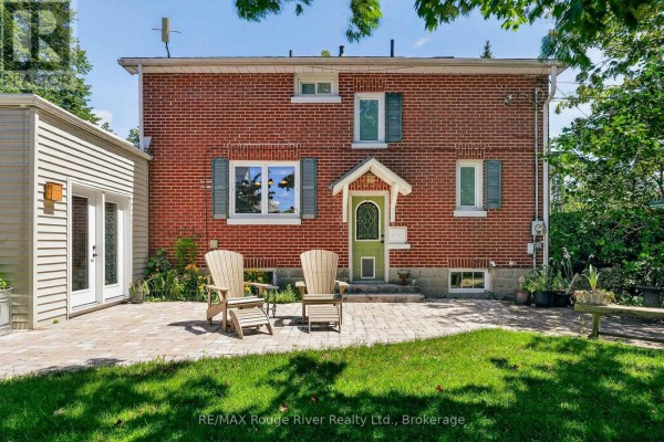 Front facade of a two-story red brick home with white trim and a covered entryway. - 208 Albert Street, Cobourg