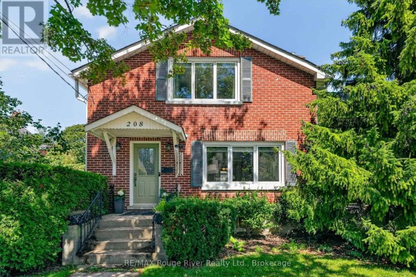 Steps leading to the front door of a brick house, flanked by lush green hedges. - 208 Albert Street, Cobourg